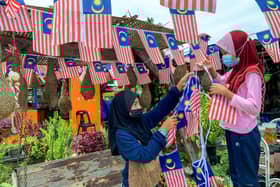 Dua gadis kecil hias gerai makan ibu guna Jalur Gemilang