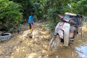 Sukarelawan gali parit buang lumpur tebal rumah mangsa bah di Baling