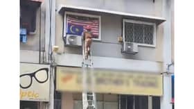 士拉央发现倒挂国旗 消拯员爬楼梯移走