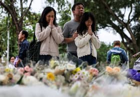 Mourners throng site of deadly Hong Kong blaze as Beijing warns against protests