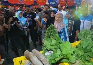 Visitors & traders at Guar Perahu Farmers' Market crowd around Kak Wan