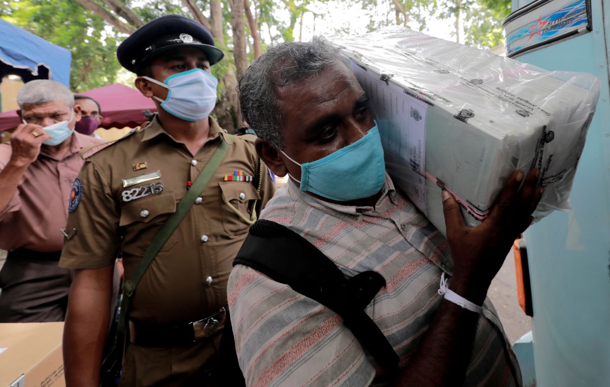 Sri Lankans, wearing masks, flock to voting centres for parliament election