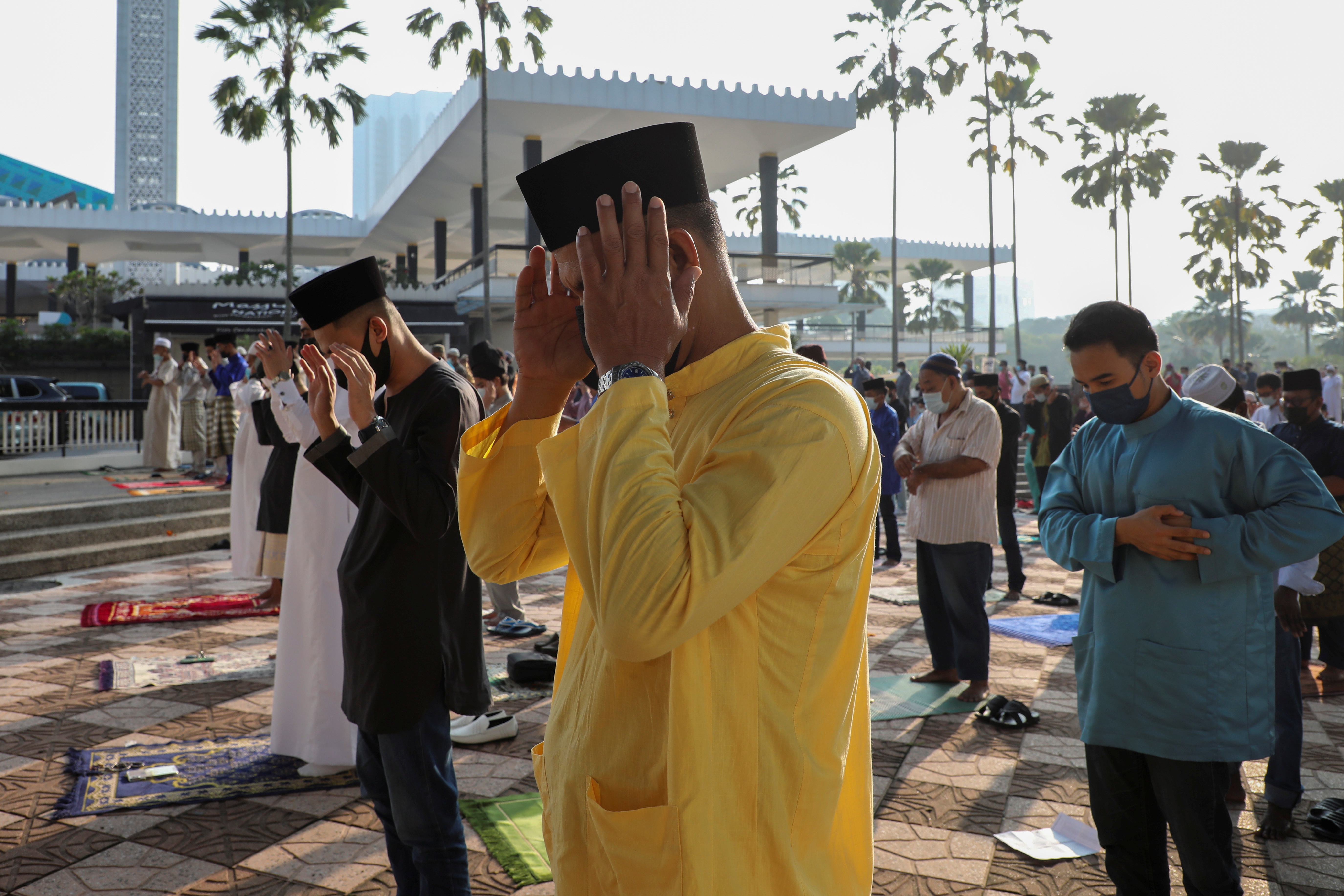 Masked and restricted by Covid-19, Muslims celebrate Eid al-Fitr