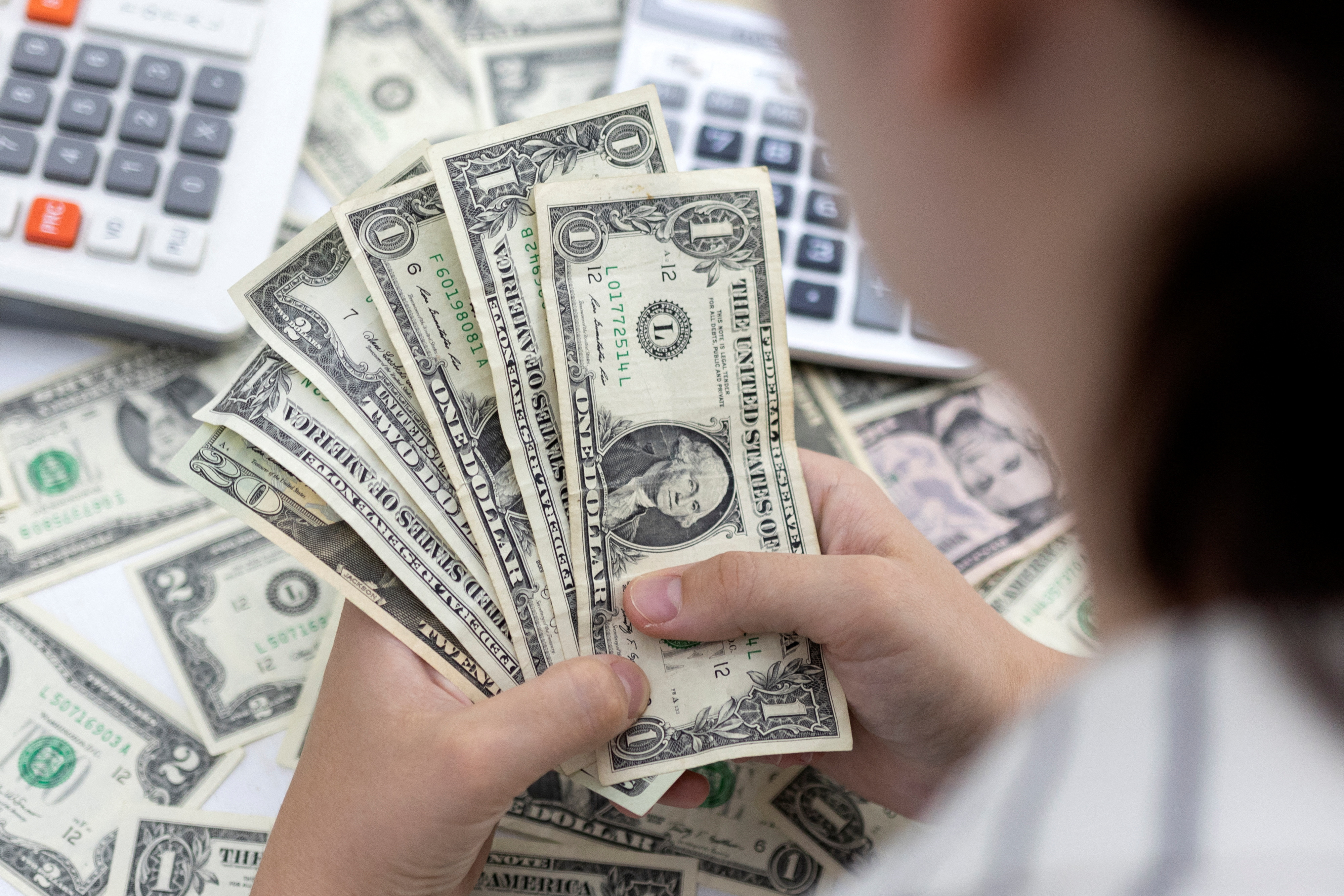 US dollar edges down amid economic data, gold rises
