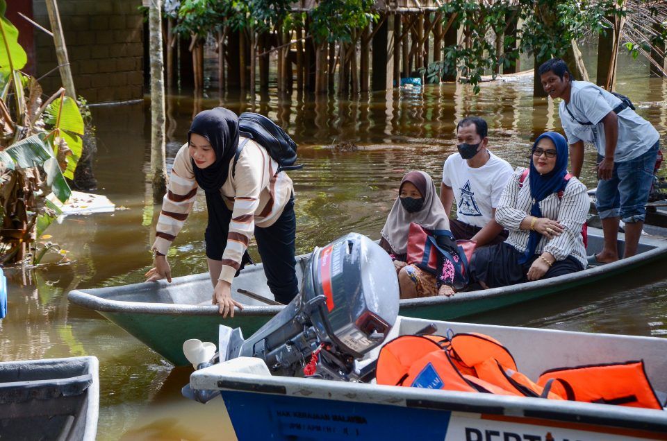 家园遭洪水淹没 灾黎一家乘船去投票