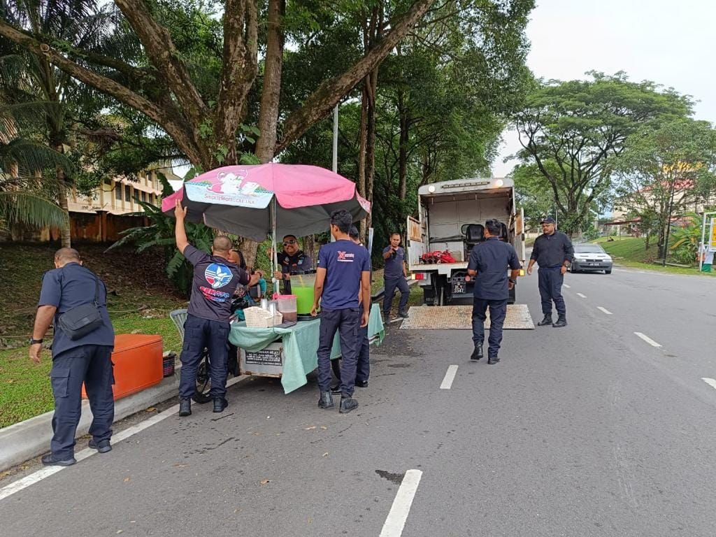 小贩固执在路边摆卖 官员为策安全扣押摩托车工具