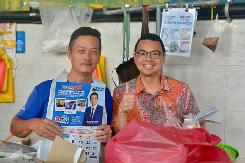 走入社区派发月历聆听民声  李健聪开心商民主动打招呼交流